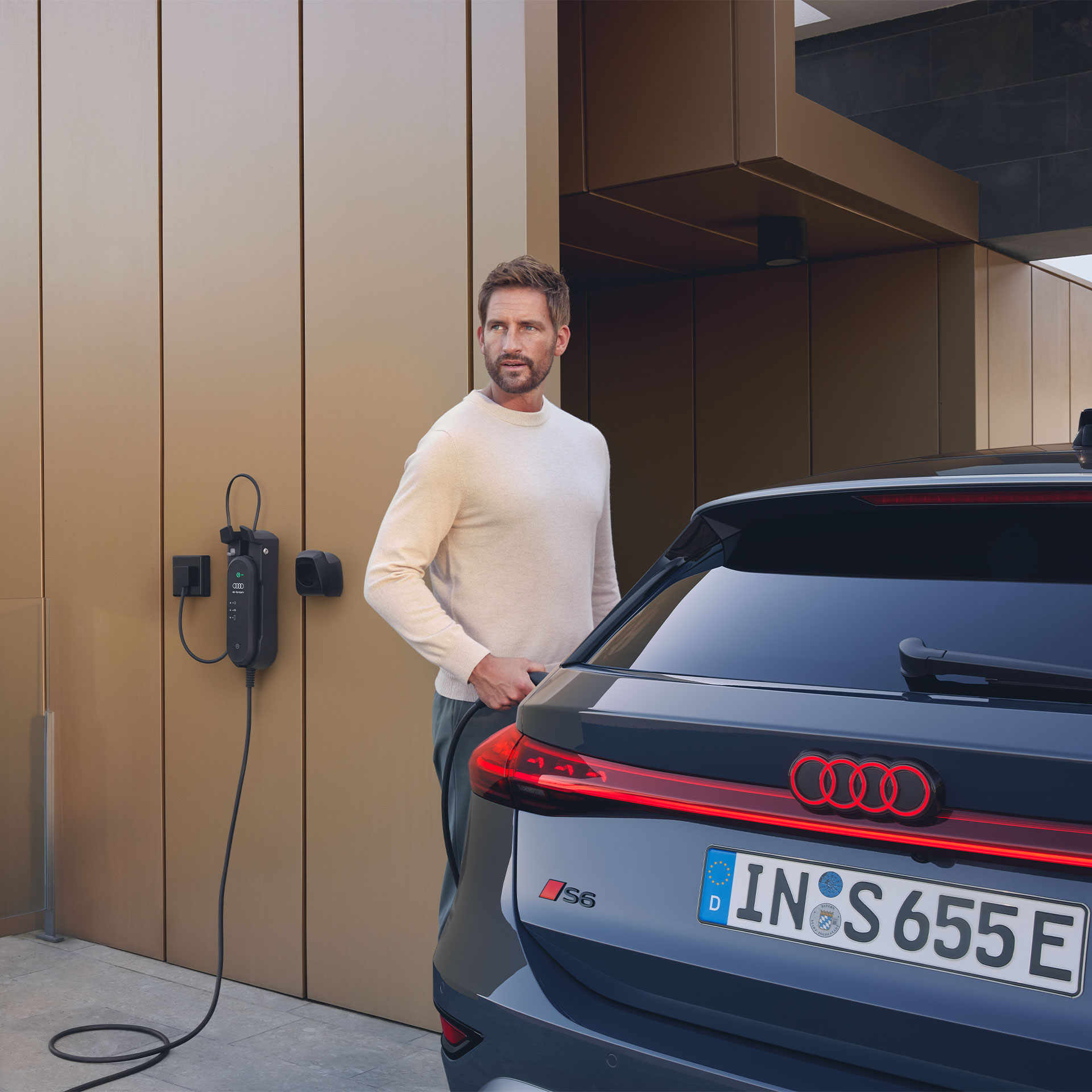 Mann lädt Audi S6 Avant e-tron