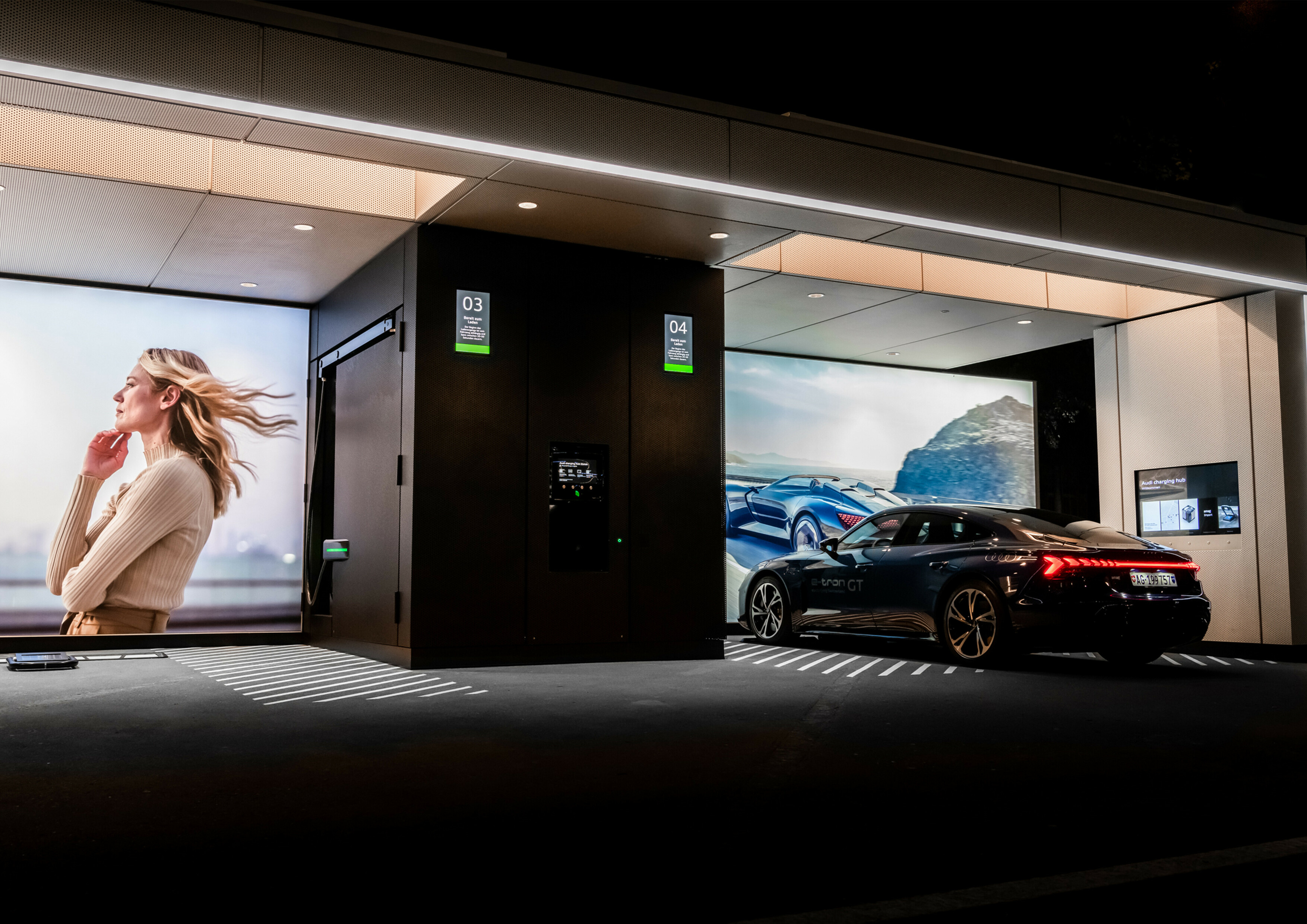 Lounge nabíjacieho miesta Audi charging hub s veľkými obrazovkami.