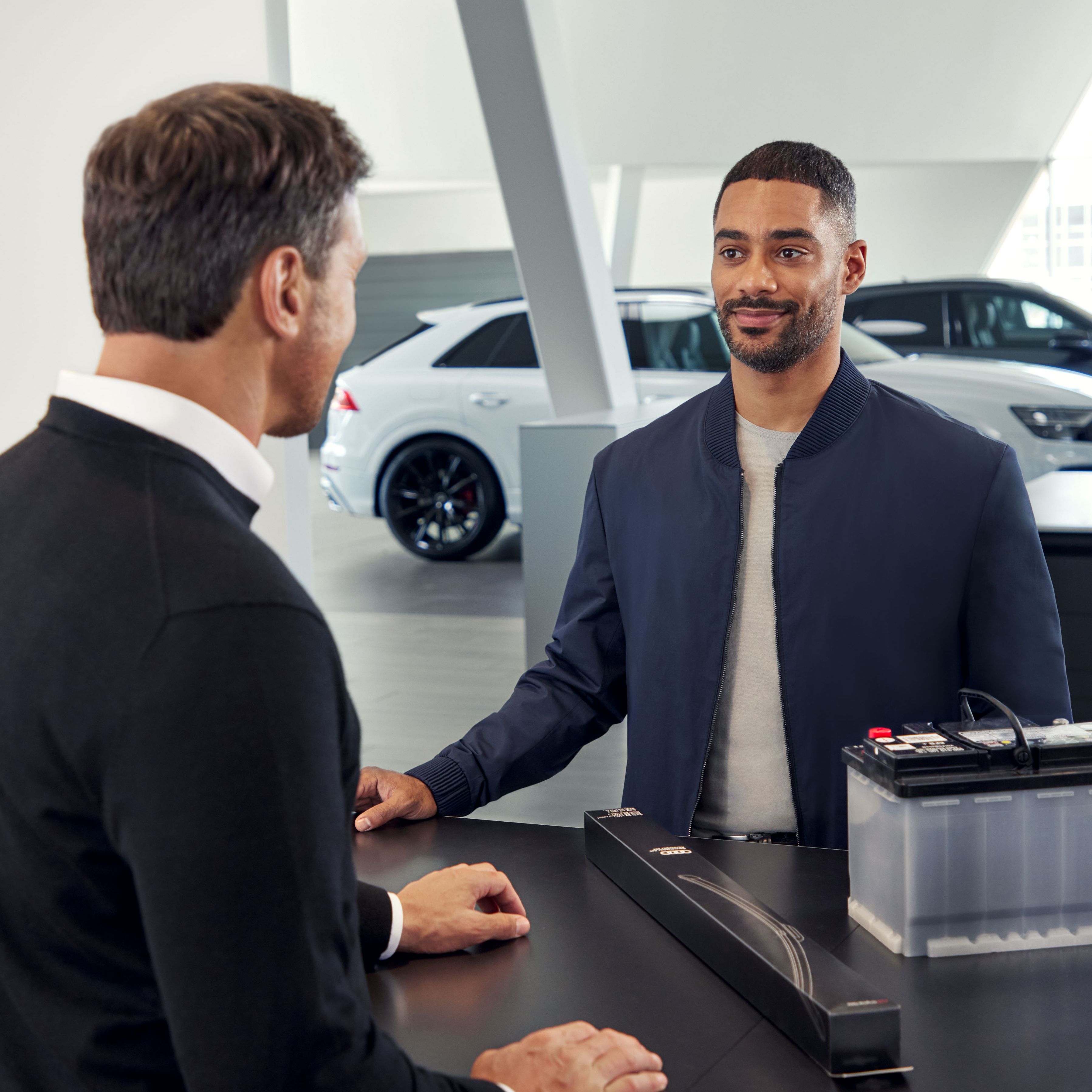 Ein Audi Service Mitarbeiter unterhält sich mit einem Kunden