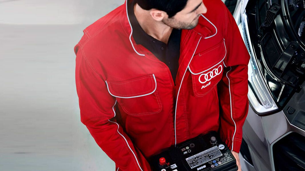 Audi Mechaniker wechselt eine Starterbatterie