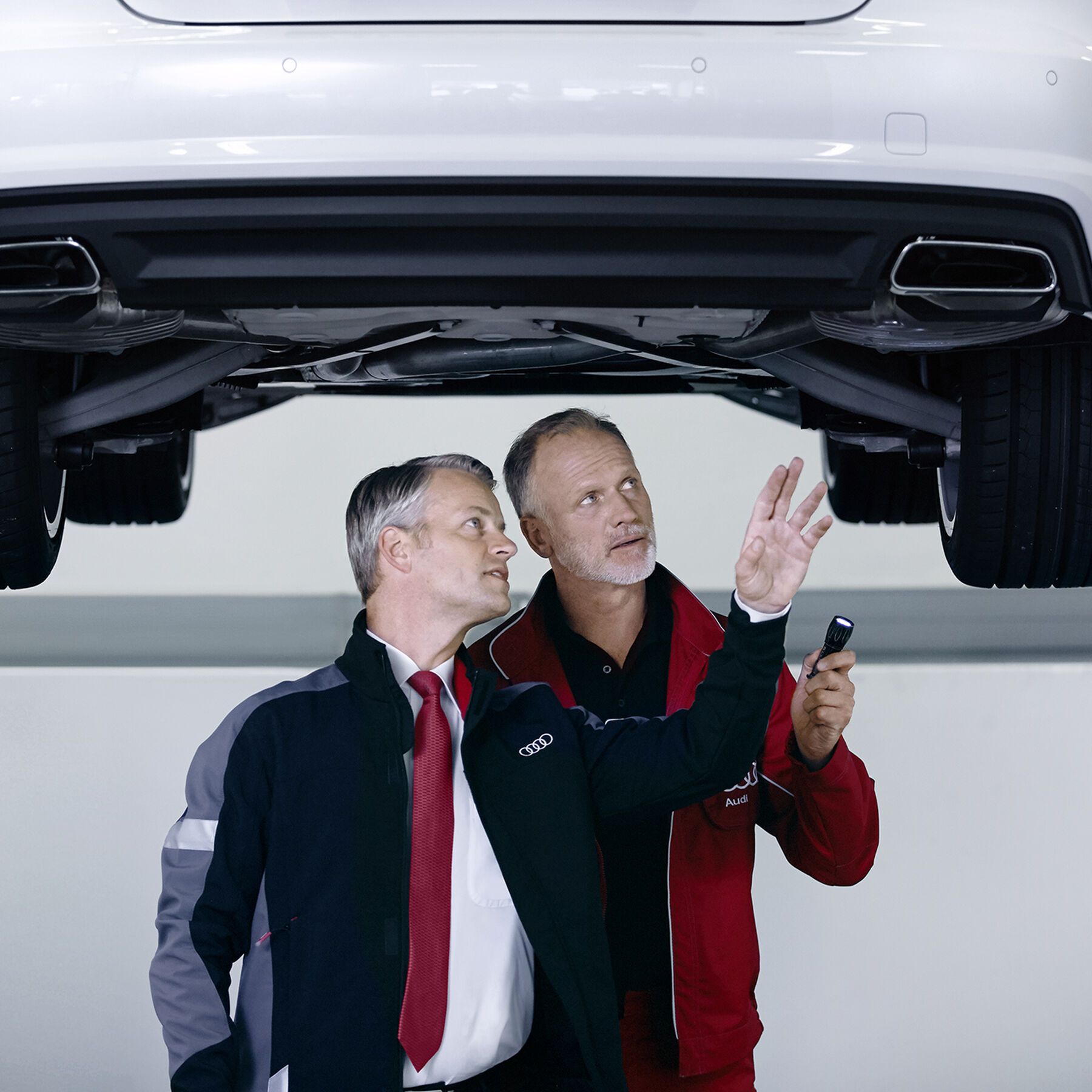 Zwei Audi Mechaniker führen die Pickerl-Überprüfung bei einem Audi durch