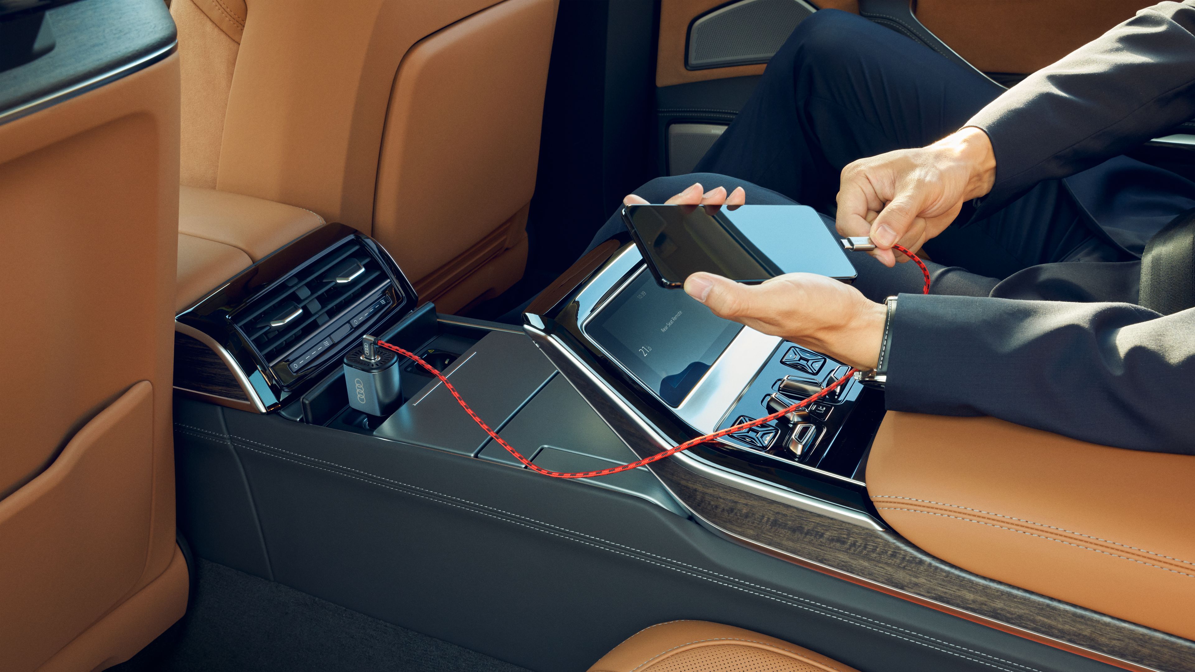 Ein Smartphone wird in einem Audi Fahrzeug an ein Ladekabel gesteckt
