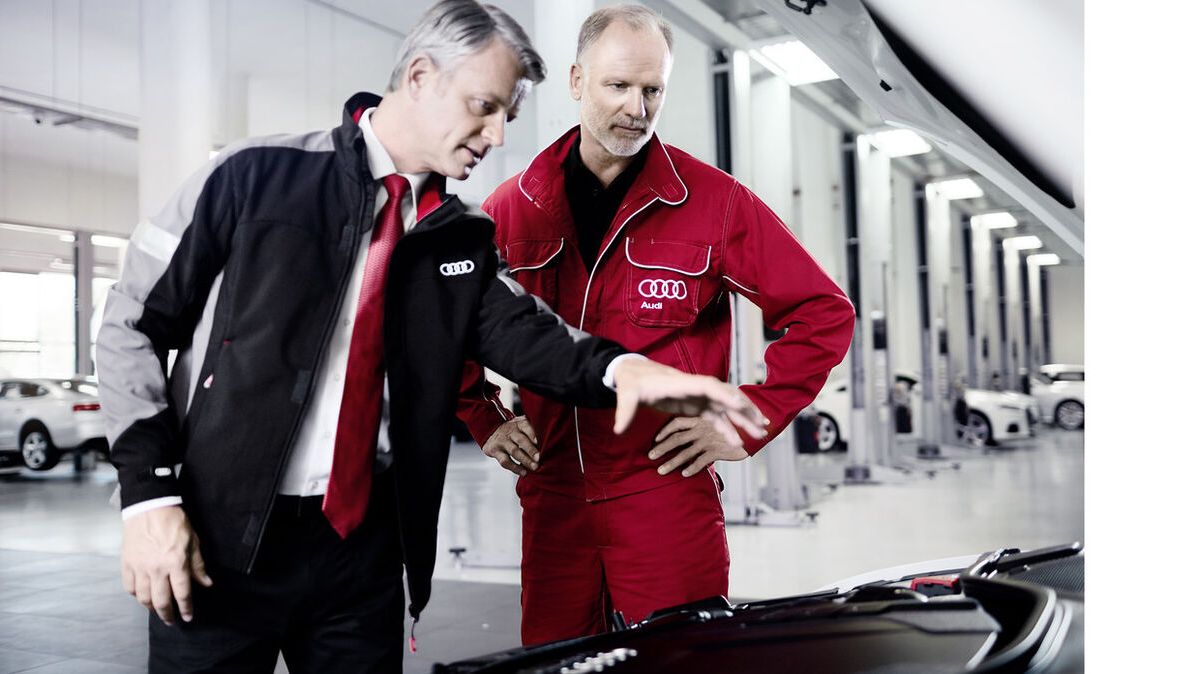 Zwei Audi Service Partner schauen sich ein Audi Modell an