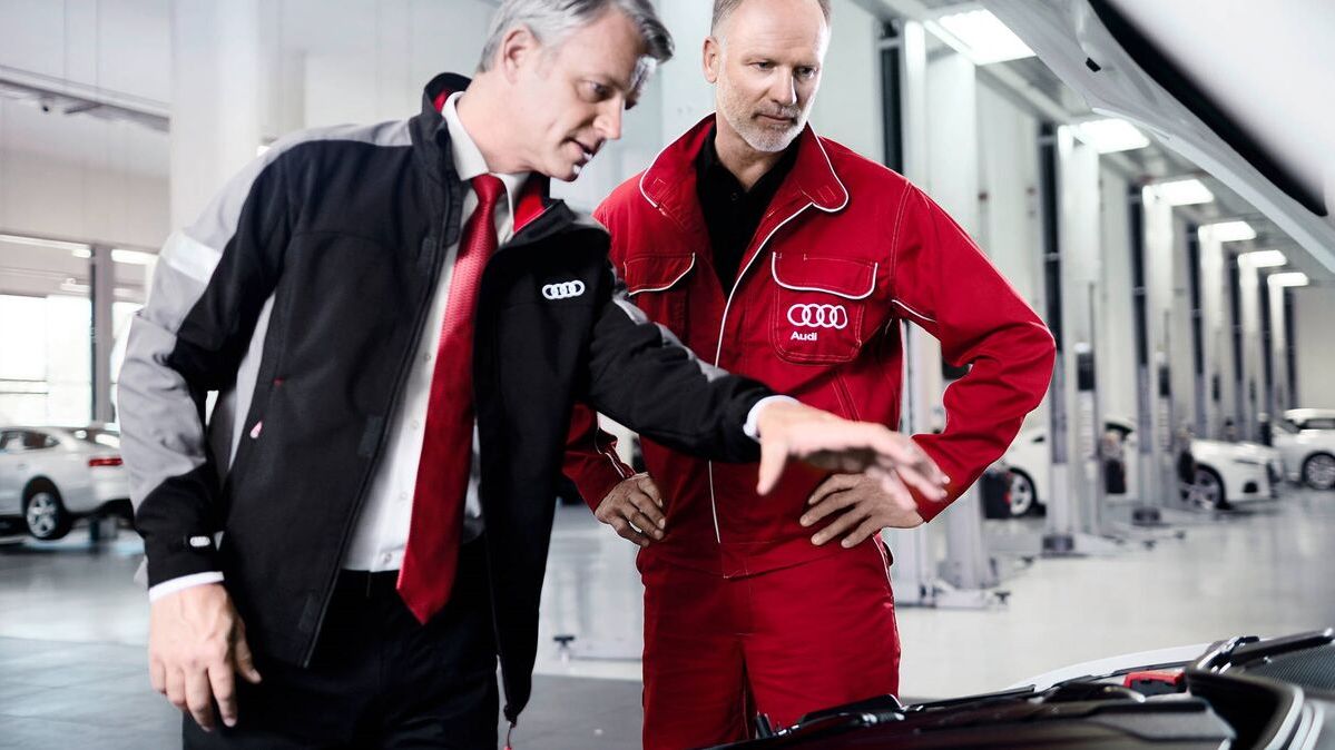 Zwei Audi Service Partner unterhalten sich in einer Audi Werkstatt