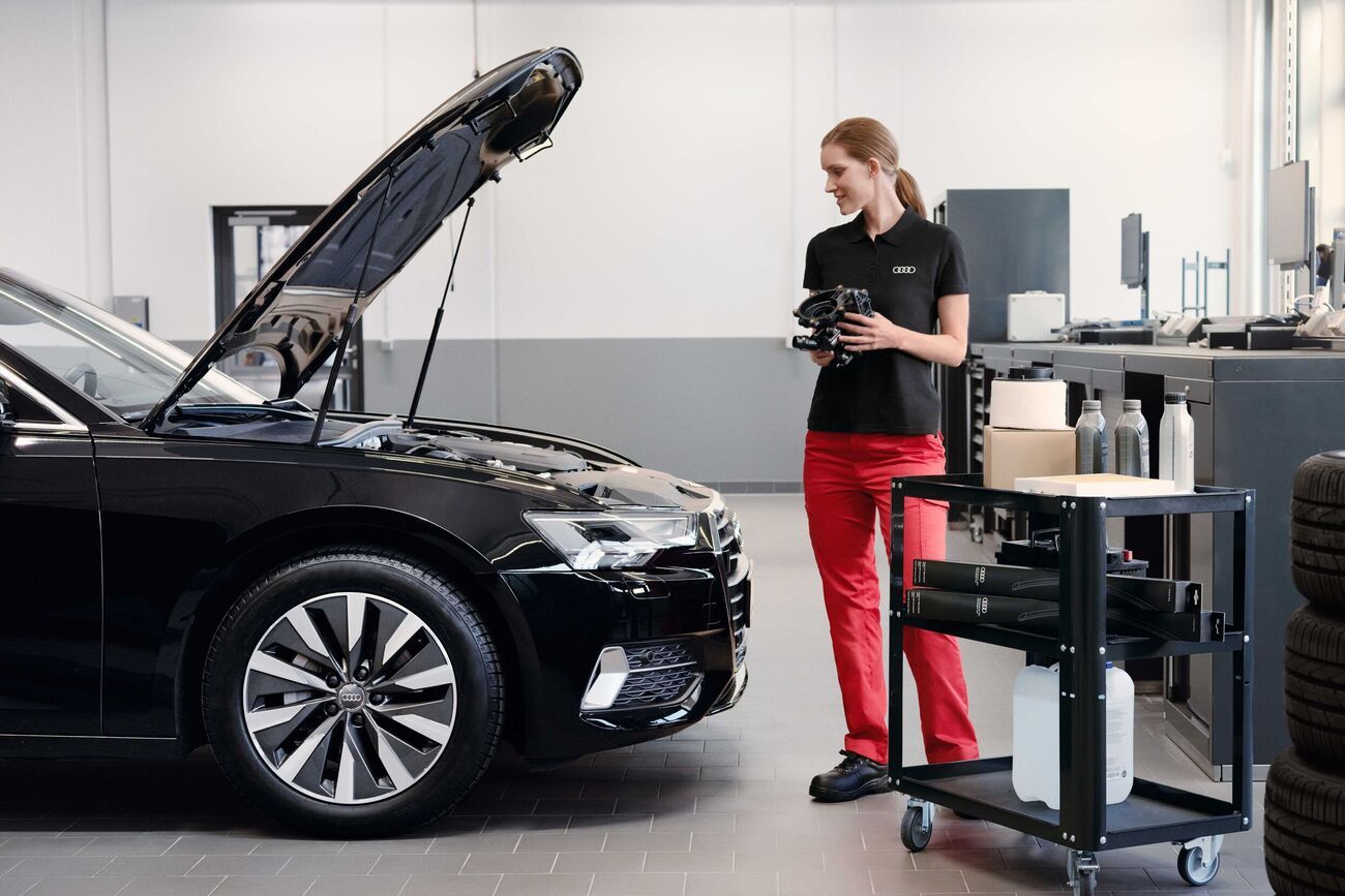 Eine Audi Service Technikerin vor einem Audi