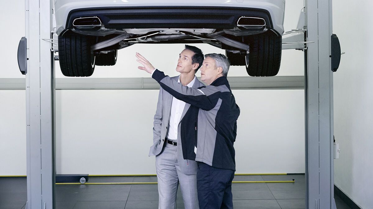Zwei Audi Service Partner kontrollieren die Stoßdämpfer bei einem Audi