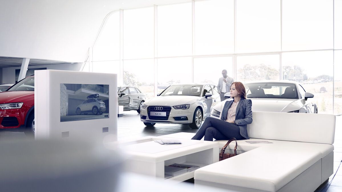 Frau sitzt in Audi Schauraum 