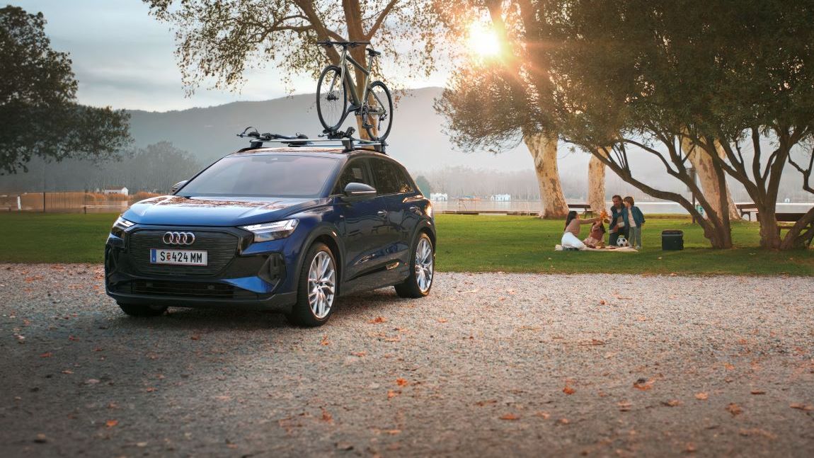 Ein blauer Audi mit Fahrradträger und Fahrrad auf dem Dach.