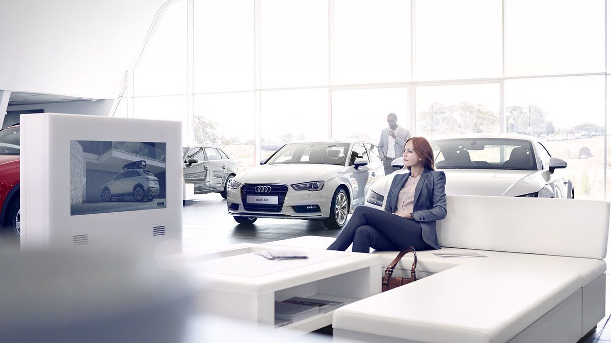 Eine Frau sitzt auf dem Sofa eines Audi Showroom
