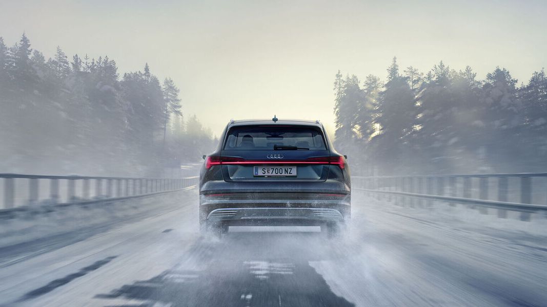 Ein Audi fährt auf einer schneebedeckten Autobrücke