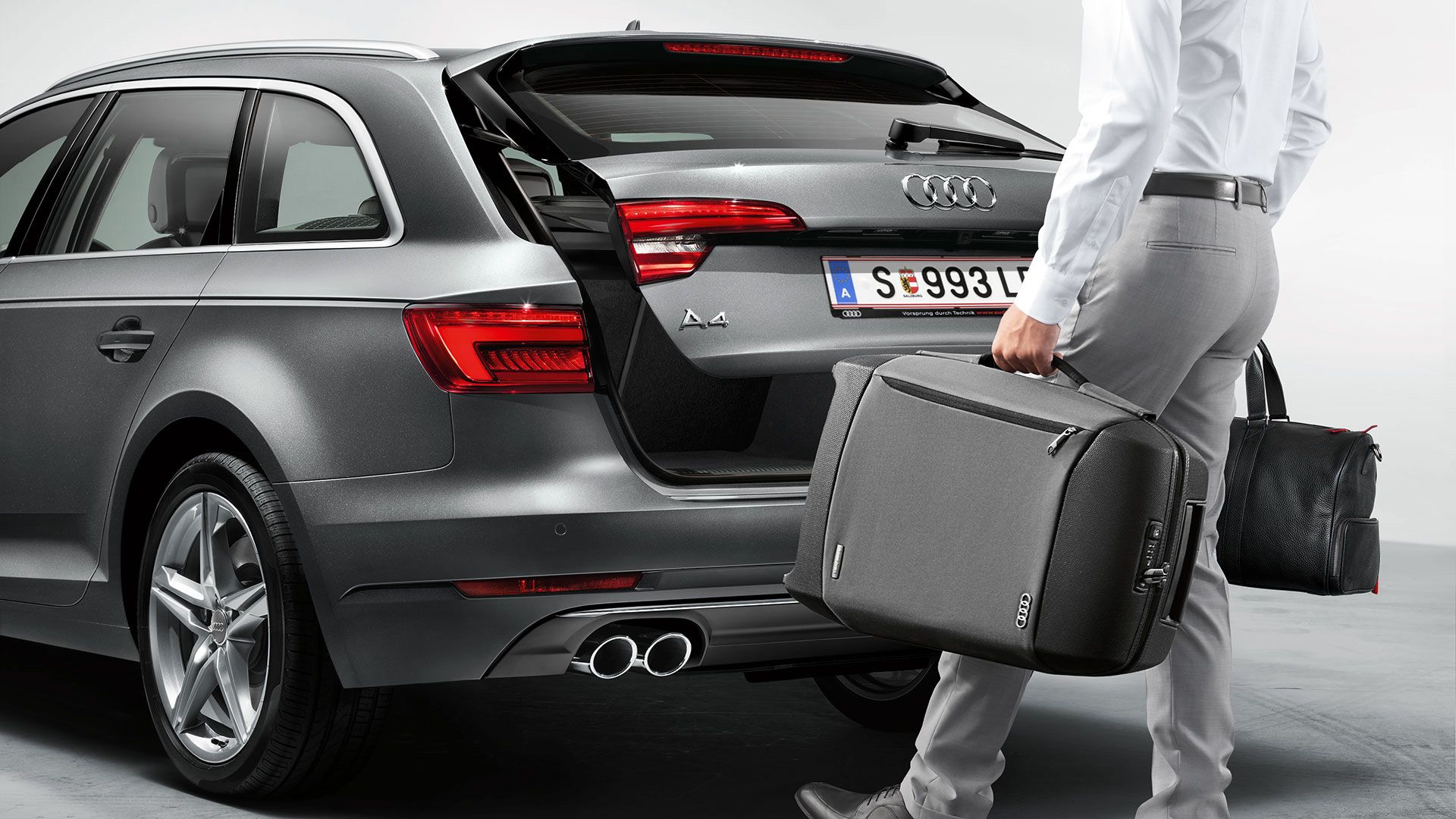 Ein Mann belädt den Kofferraum eines Audi